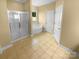Bathroom featuring a glass-enclosed shower, soaking tub, and neutral tile at 13419 Morgan Lee Ave, Charlotte, NC 28213