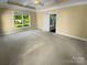 Large bedroom featuring a tray ceiling and a bright window with a peaceful backyard view at 13419 Morgan Lee Ave, Charlotte, NC 28213