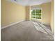 Light-filled bedroom with a large window and neutral carpet at 13419 Morgan Lee Ave, Charlotte, NC 28213