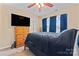 Bedroom features a cozy bed, ceiling fan, a dresser, and blue curtains at 1609 Begonia Way, Rock Hill, SC 29732