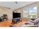 Comfortable living room with hardwood floors, a large TV, and a view of the staircase at 1609 Begonia Way, Rock Hill, SC 29732