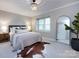 Cozy bedroom with a decorative chandelier, large mirror, and neutral color palette at 1708 Roxborough Rd # C, Charlotte, NC 28211