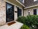 Charming brick facade with a black front door, black shutters, and neatly trimmed greenery at 1708 Roxborough Rd # C, Charlotte, NC 28211