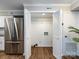 Convenient laundry room featuring white bi-fold doors, stainless steel fridge, and neutral paint at 1708 Roxborough Rd # C, Charlotte, NC 28211
