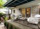 Relaxing covered patio with wicker furniture and a neutral outdoor rug at 1708 Roxborough Rd # C, Charlotte, NC 28211