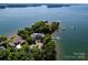Gorgeous aerial shot of lakefront property featuring mature trees, a private dock, and manicured landscaping at 175 Rehoboth Ln, Mooresville, NC 28117