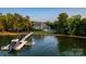 Aerial view of waterfront property with a private dock, boat, and stunning home nestled among mature trees at 175 Rehoboth Ln, Mooresville, NC 28117