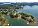 Expansive aerial view of a luxury home surrounded by lush trees with a private dock on the lake at 175 Rehoboth Ln, Mooresville, NC 28117