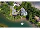 Stunning aerial view of lakefront home with private dock and pool amidst lush greenery at 175 Rehoboth Ln, Mooresville, NC 28117