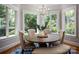 Charming dining nook with bay windows offering lush views and elegant seating around a round wooden table at 175 Rehoboth Ln, Mooresville, NC 28117
