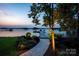 Picturesque dock with boat slips on the tranquil lake, surrounded by lush greenery and landscaping at 175 Rehoboth Ln, Mooresville, NC 28117
