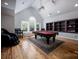 Spacious game room features a pool table, vaulted ceilings, a large window, and custom built-in shelving at 175 Rehoboth Ln, Mooresville, NC 28117