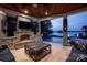 Inviting covered outdoor living space with stone fireplace and seating overlooking the pool and lake at 175 Rehoboth Ln, Mooresville, NC 28117