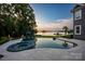 Serene pool and spa area overlooking the lake, complemented by manicured landscaping and outdoor seating at 175 Rehoboth Ln, Mooresville, NC 28117