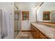 Bathroom with double sinks, wood cabinets, and a tiled walk-in shower at 177 Yadkin Falls Rd, New London, NC 28127
