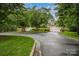 Scenic view of the community entrance with white gates, lush trees and manicured lawns at 177 Yadkin Falls Rd, New London, NC 28127