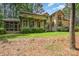 An expansive rear elevation featuring a screened in porch, stone accents, and lush landscaping at 177 Yadkin Falls Rd, New London, NC 28127