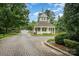 Charming gatehouse with brick-paved entrance, stone wall, and lush landscaping at 177 Yadkin Falls Rd, New London, NC 28127