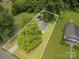 Bird's eye view showcasing the house, yard, outbuilding, trees, and overall property boundaries at 201 Oakland Dr, Lowell, NC 28098