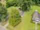 Aerial view showcasing the house and its surrounding greenery, plus the gravel driveway at 201 Oakland Dr, Lowell, NC 28098