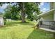 Grassy backyard featuring a large tree, and multiple storage sheds at 201 Oakland Dr, Lowell, NC 28098