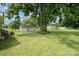 Large grassy backyard featuring a grill and multiple storage sheds at 201 Oakland Dr, Lowell, NC 28098