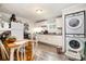 Eat-in kitchen with white cabinets, a refrigerator, and a stacked washer and dryer at 201 Oakland Dr, Lowell, NC 28098
