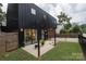 Modern home with fenced backyard, concrete patio, outdoor lighting, and black exterior at 2107 W Trade St, Charlotte, NC 28216