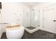 Stylish bathroom with a freestanding tub and glass-enclosed shower with unique tile flooring at 2107 W Trade St, Charlotte, NC 28216