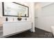 Modern bathroom featuring a dual sink vanity, large mirror, and sleek black tile flooring at 2107 W Trade St, Charlotte, NC 28216