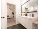 Modern bathroom with double sink vanity, dark tile flooring, and bedroom view at 2107 W Trade St, Charlotte, NC 28216