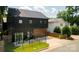 Modern black home with metal roof, garage, fenced yard, and patio seating area at 2107 W Trade St, Charlotte, NC 28216