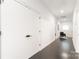 Hallway with hardwood floors, white walls, and a glimpse into a light-filled sitting area at 2107 W Trade St, Charlotte, NC 28216
