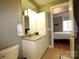 Bathroom with granite-topped vanity and an open doorway to the bedroom at 230 S Tryon St # 304, Charlotte, NC 28202