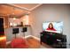 Living room featuring hardwood floors, a TV, and open floor plan adjacent to the kitchen at 230 S Tryon St # 304, Charlotte, NC 28202