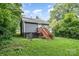 Rear view of a house with stairs leading up to the back door, surrounded by greenery at 2312 Tate St, Charlotte, NC 28216
