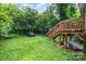View of the backyard featuring lush greenery and a wooden deck with stairs at 2312 Tate St, Charlotte, NC 28216