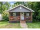 Charming bungalow with a covered porch, chairs, and lush landscaping at 2312 Tate St, Charlotte, NC 28216