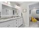 Bright bathroom with granite countertop, double sinks, and white cabinets, next to what seems to be bedroom at 307 E Allenton St, Mount Gilead, NC 27306