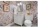 Charming bathroom with ornate mirror, bird-themed wallpaper and sink with white cabinets at 307 E Allenton St, Mount Gilead, NC 27306