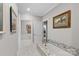 Hallway view with tub, granite counter and herringbone tile floor in neutral tones at 307 E Allenton St, Mount Gilead, NC 27306