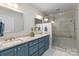 A bathroom with double sinks, a granite counter, and a glass enclosed shower at 307 E Allenton St, Mount Gilead, NC 27306