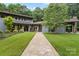 Modern home exterior with stone walkway, manicured lawn, and lush landscaping at 307 E Allenton St, Mount Gilead, NC 27306