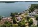 Aerial view of the luxury lakefront home, showcasing lake views, boat docks, landscaping, mature trees, and neighborhood at 3996 Channel Point Ln, Denver, NC 28037