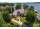 Aerial view of estate home featuring manicured landscaping, expansive lawn, and a private driveway and lake views at 3996 Channel Point Ln, Denver, NC 28037