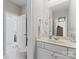 Bright bathroom featuring a vanity, large mirror, and doorway to an adjacent room at 3996 Channel Point Ln, Denver, NC 28037