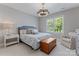Neutral bedroom with a decorative light fixture, window, and white chair at 3996 Channel Point Ln, Denver, NC 28037