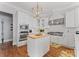 Elegant white kitchen with a wood island, stainless steel appliances, and designer lighting at 3996 Channel Point Ln, Denver, NC 28037