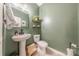 Charming powder room featuring green walls, pedestal sink, and decorative accents at 4113 Bent Green Ln, Monroe, NC 28112