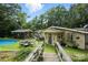 A lovely, elevated backyard view with a pool, dining set, and a wooden bridge to an expansive property at 4412 Dobys Bridge Rd, Fort Mill, SC 29707